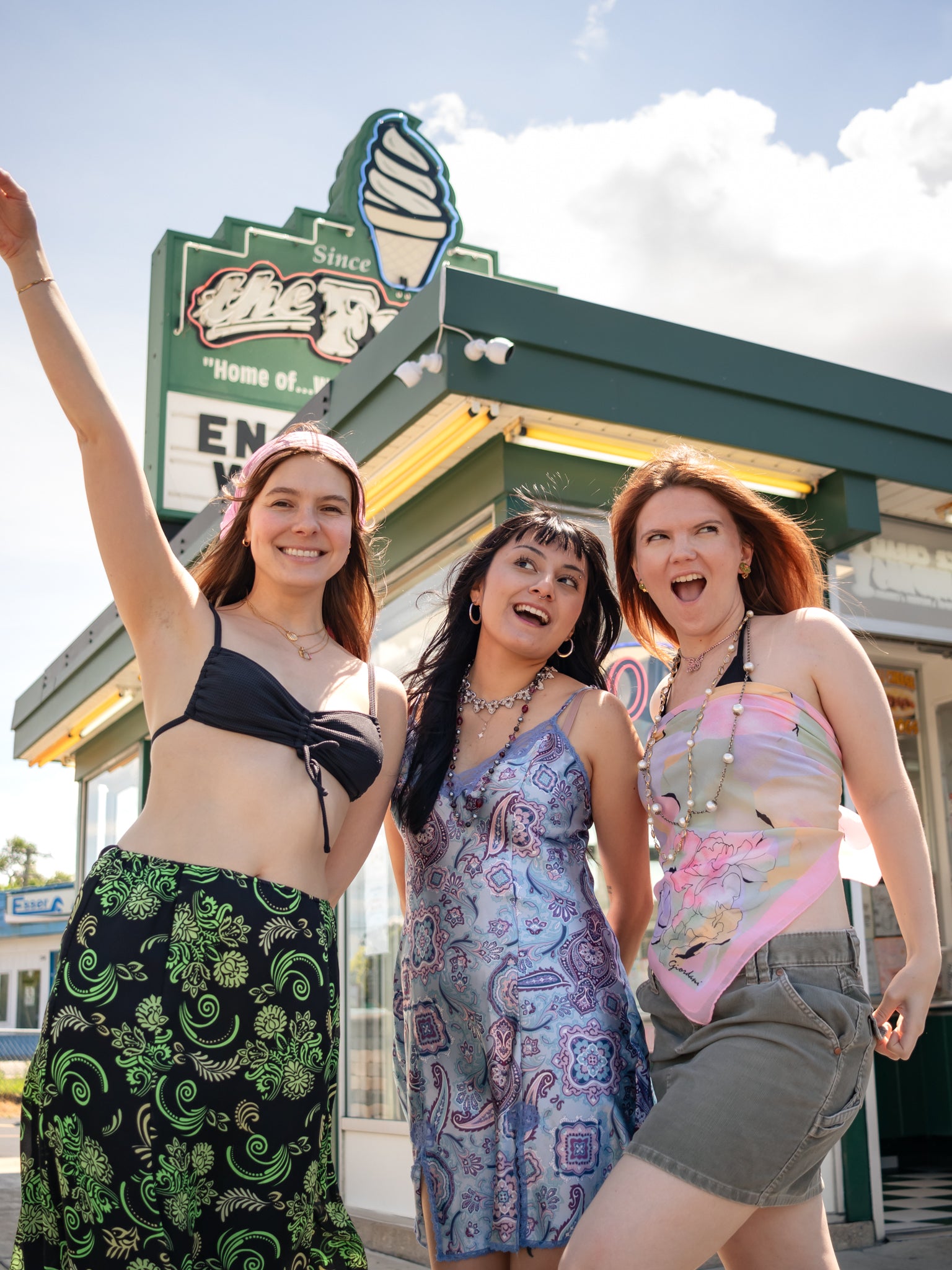 Three young women in vintage outfits pose outside the Freeze in Crystal Lake Illinois